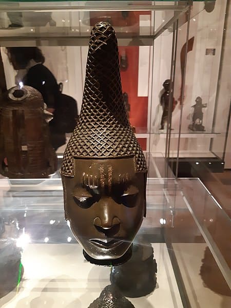 A buddha head is on display in a glass case.