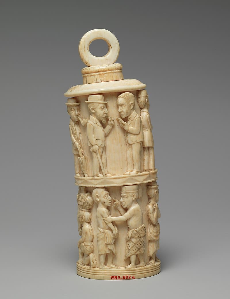 A carved ivory container with figures on it.