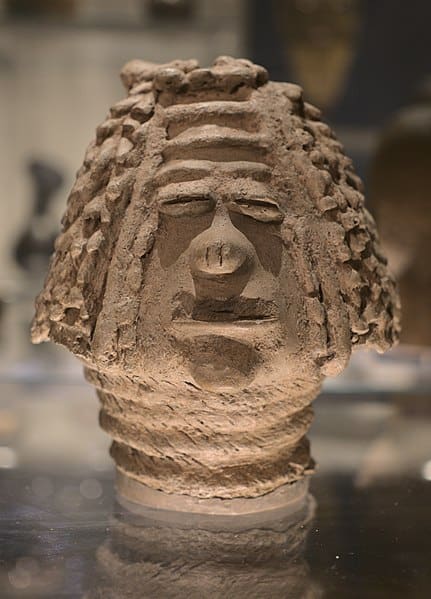 A clay head is on display in a museum.