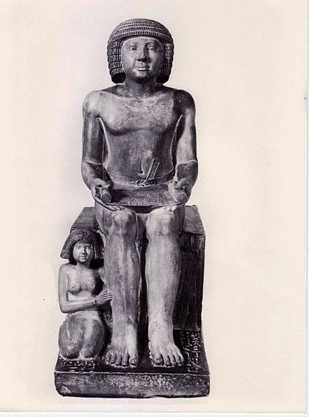 A statue of an egyptian pharaoh holding a child.