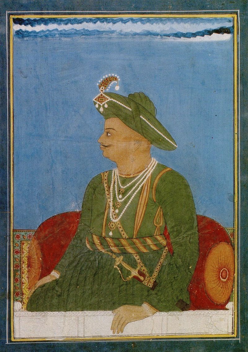 An indian painting of a man sitting on a couch.