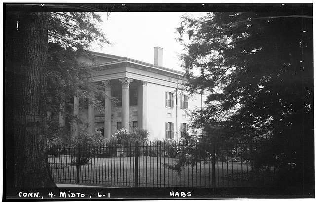 A black and white photo of a large mansion.