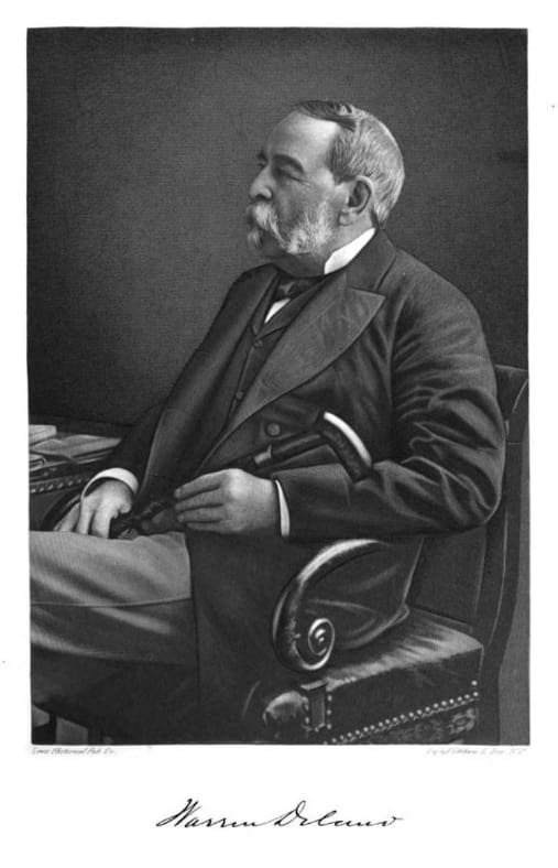 A black and white photograph of a man sitting in a chair.