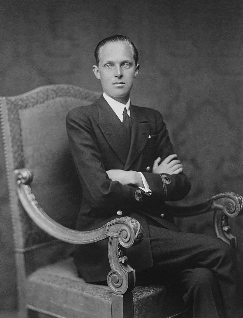 A man in a suit sitting in a chair.