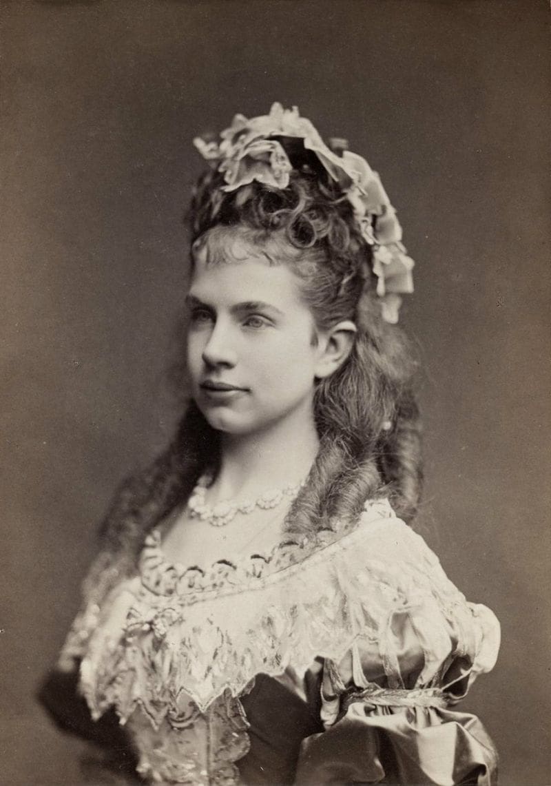An old photo of a young woman in a fancy dress.