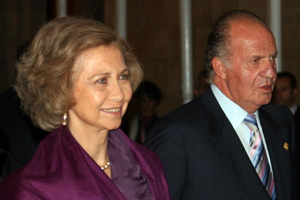 A woman in a purple suit standing next to a man in a suit.