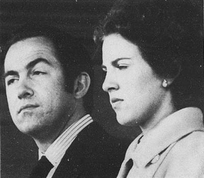 A black and white photo of a man and woman staring at each other.